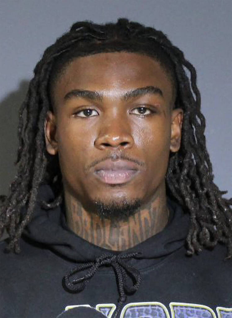 Rashee Rice in a mugshot photo wearing a black hoodie with visible neck tattoos and long dreadlocks.
